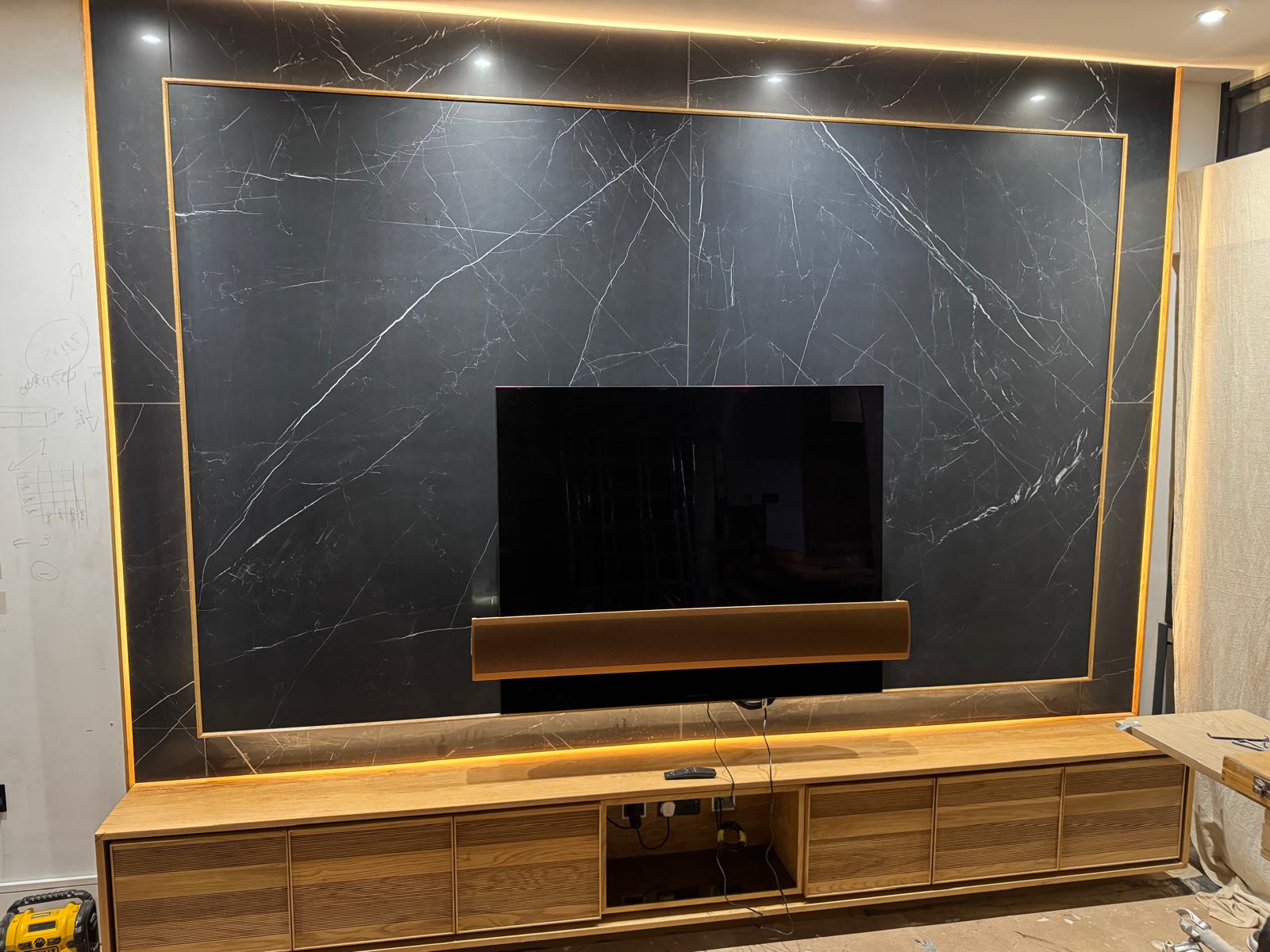 Marble media wall with warm lighting and bespoke timber storage